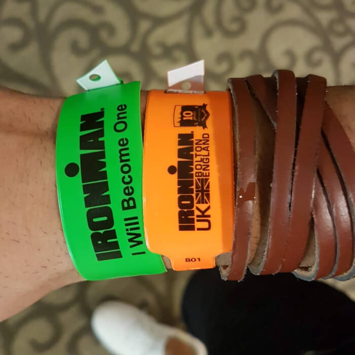 1 brown laced bracelet, 1 green I will become one Ironman band and 1 orange Ironman UK Bolton band on Domenico Buonocore's wrist